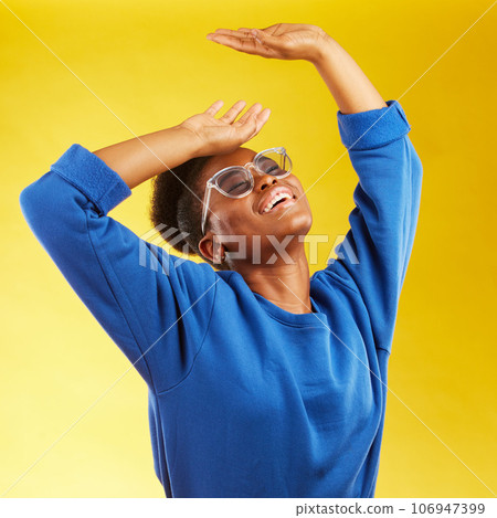 Fashion, freedom and fun with a black woman on a yellow background in studio for trendy gen z style. Relax, smile and excited with a happy young girl indoor to dance with a carefree expression 106947399