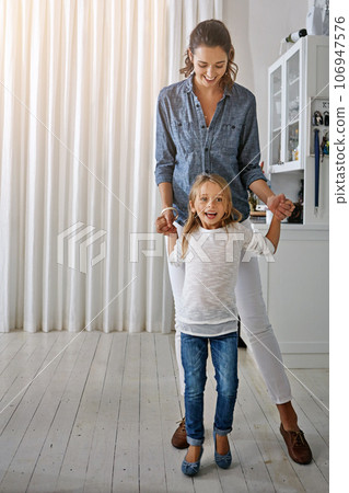 Playful, happy and portrait of a mother and child with quality time in the living room of a house. Smile, happiness and girl playing with her mom in the lounge of their home together on the weekend 106947576