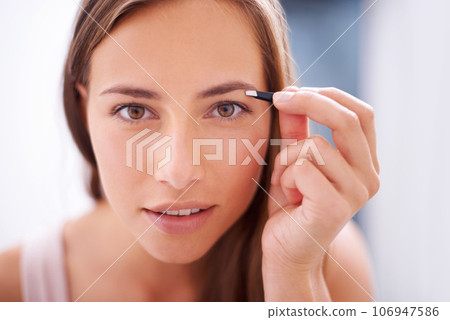 Woman, tweezers and eyebrows in bathroom portrait for skincare, beauty or cosmetics for face in home. Girl, facial hair removal and cosmetic tools for brows, aesthetic or wellness in morning at house 106947586