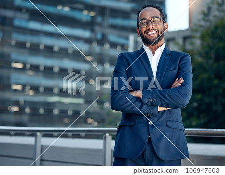 The best businessman. Shot of a young businessman standing with his arms crossed against a city background. The best businessman. Shot of a young businessman standing with his arms crossed against a city background. 106947608