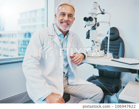 Optometry, healthcare and portrait of a male optometrist sitting by equipment in a optical clinic. Vision, medical and senior man eye care specialist with a retinoscope machine in a optic store. 106947622