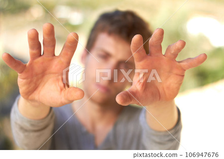 Hefty hard hands. A handsome young man holding up his calloused hands. Hefty hard hands. A handsome young man holding up his calloused hands. 106947676