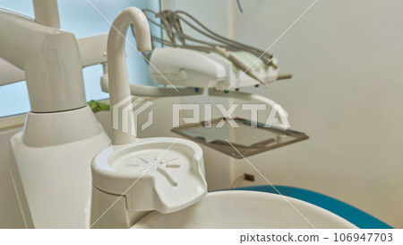 Modern dental office. Dental chair and other accessories used by dentists in blue, medical light Modern dental office. Dental chair and other accessories used by dentists in blue, medical light 106947703