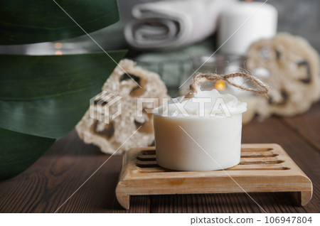 Natural soap, loofah scrubber on podium in bathroom. Zero waste in life. Relaxation spa concept, candles, beauty... Natural soap, loofah scrubber on podium in bathroom. Zero waste in life. Relaxation spa concept, candles, beauty... 106947804