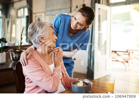 Healthcare, elderly woman with nurse with breakfast at her home and at the table in living room. Support or communication, caregiver and conversation with medical person with senior or old female. Healthcare, elderly woman with nurse with breakfast at her home and at the table in living room. Support or communication, caregiver and conversation with medical person with senior or old female. 106947809
