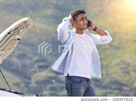 When can you guys get here. Cropped shot of a handsome young man on the phone with roadside assistance after suffering a vehicle breakdown. When can you guys get here. Cropped shot of a handsome young man on the phone with roadside assistance after suffering a vehicle breakdown. 106947828