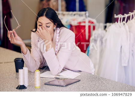 Headache, tired and a fashion designer at a boutique for planning, burnout and sad from design fail. Stress, workshop and a woman with anxiety, fatigue or depression from working as a tailor 106947829