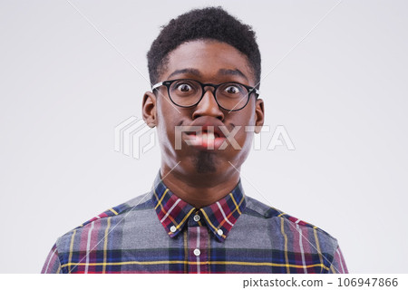 Funny face, comic and portrait of a black man being crazy isolated on a white background in a studio. Geek, mouth movement and face headshot of an African person with glasses as a nerd and goofy Funny face, comic and portrait of a black man being crazy isolated on a white background in a studio. Geek, mouth movement and face headshot of an African person with glasses as a nerd and goofy 106947866