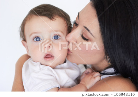 Happy, kiss and care with mother with baby for bonding, affectionate and growth. Happiness, love and family with face of woman and kissing young child on cheek for cute, sweet and kindness 106948110