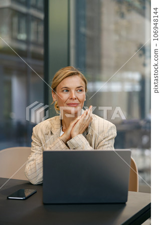 Stylish business woman sitting in modern coworking and working on laptop. High quality photo 106948144