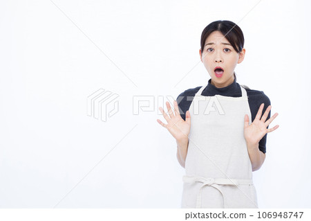 一位 30 多歲的家庭主婦在白色背景前看起來很驚訝 一位 30 多歲的家庭主婦在白色背景前看起來很驚訝 106948747