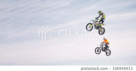 Sky, jump and men on motorbike together for practice, training and extreme sports energy in mockup. Professional dirt biking challenge, friends in air and danger with off road motorcycle competition. 106948913