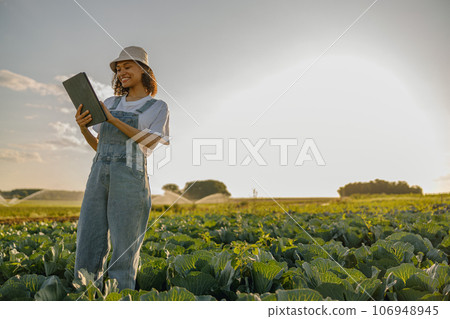 Woman farmer work on digital tablet standing on cabbage field. Agricultural business concept 106948945