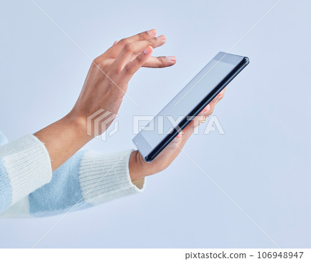 Hands, tablet and person on studio for social media, reading ebook and search website on gray background. Closeup, model and digital technology for connection, download and scroll online shopping app 106948947