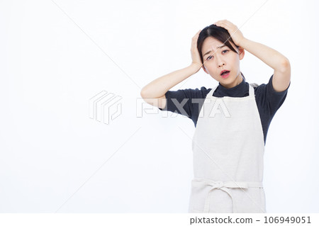 A surprised housewife in her 30s holding her head in front of a white background 106949051