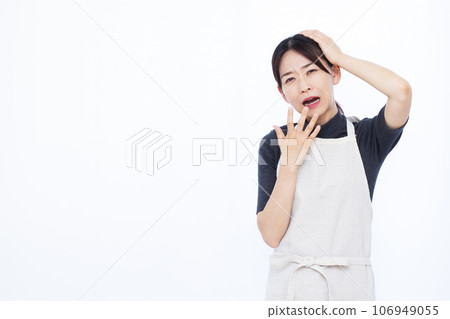 A surprised housewife in her 30s holding her head in front of a white background A surprised housewife in her 30s holding her head in front of a white background 106949055