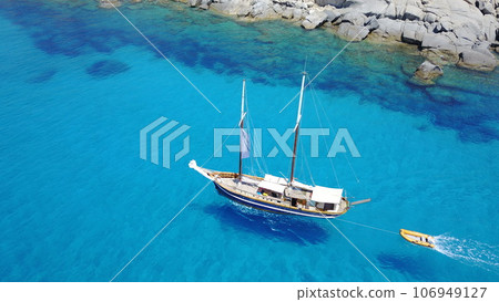 Boat, sailing in blue water and summer sun on ocean holiday, relax in freedom and nature. Yacht vacation, aerial of travel and tropical cruise on adventure to Greek island with sunshine, fun and sea. 106949127