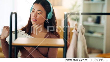 Woman, closet and fashion listening to music dance while looking at clothes in home bedroom. Girl, happy and outfit dancing in shop, store or boutique for shopping, streaming and song on headphones 106949502