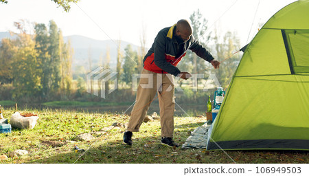 Camping, tent and black man setup in nature for shelter on outdoor holiday, vacation and adventure, Campsite, traveling and male person with hammer for pins for gear in woods, forest and countryside Camping, tent and black man setup in nature for shelter on outdoor holiday, vacation and adventure, Campsite, traveling and male person with hammer for pins for gear in woods, forest and countryside 106949503