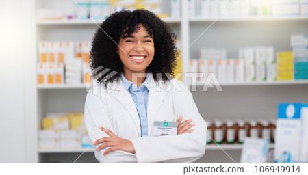 Portrait of a pharmacist with folded arms against a background of prescription medication. Happy young professional health care worker waiting to diagnose and prescribe pills at a clinic dispensary 106949914