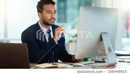 Business man analyzing a project strategy on a computer screen while working in an office. Serious and focused corporate professional thinking of solutions while considering ideas, choices and plans Business man analyzing a project strategy on a computer screen while working in an office. Serious and focused corporate professional thinking of solutions while considering ideas, choices and plans 106949915