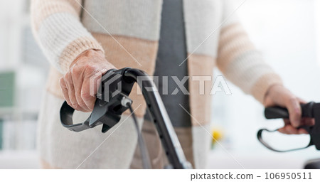 Hands, walking aid and a senior person with a disability in recover or rehabilitation in a clinic for mobility. Healthcare, medical and physiotherapy with an elderly patient in a nursing home 106950511