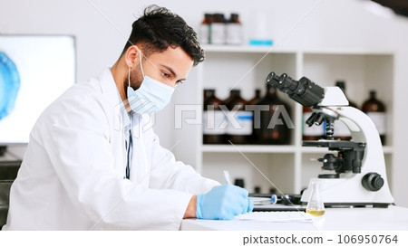 Scientist and research or medical engineer doing experiments to create a cure in a lab while wearing a mask. Healthcare professional working with science equipment and writing notes in a laboratory 106950764