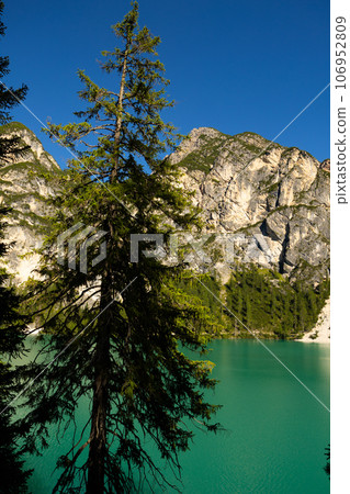 Alpine lake Braies amidst rocky peaks of Dolomite mountains, Italy Alpine lake Braies amidst rocky peaks of Dolomite mountains, Italy 106952809