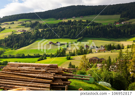 Snapshot of pile of logs neatly stacked on picturesque hill in Val di Funes region, Dolomites. 106952817