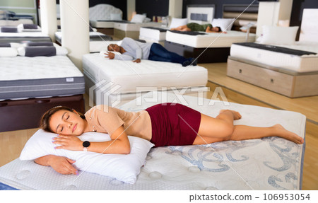 Young woman fell asleep on new mattress in a furniture store 106953054