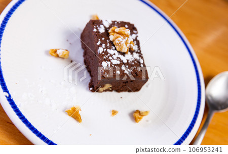 Piece of brawny with walnuts served in a plate 106953241