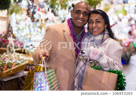 Portrait of happy elegant couple with gift bags at new year fair Portrait of happy elegant couple with gift bags at new year fair 106953265