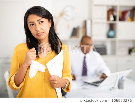 Upset businesswoman standing in office after conflict with boss 106953276