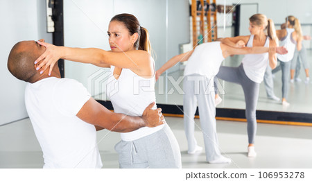 Hispanic girl using painful technique for eyes of opponent during training at gym 106953278