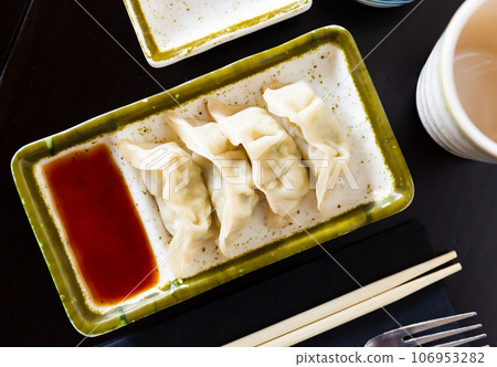 Steamed Yaki Gyoza served in a plate with sauce Steamed Yaki Gyoza served in a plate with sauce 106953282