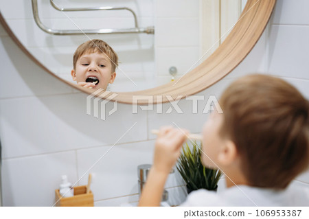 cute 5 years old boy brushing teeth with bamboo tooth brush in bathroom. Image with selective focus cute 5 years old boy brushing teeth with bamboo tooth brush in bathroom. Image with selective focus 106953387