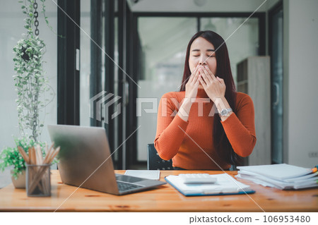 Bored businesswoman yawning at workplace feeling no motivation or lack of sleep tired of boring office routine. 106953480