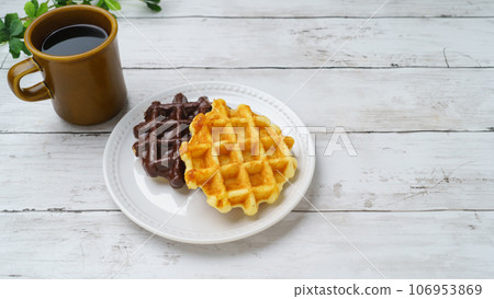 Waffles and coffee on white wood background Waffles and coffee on white wood background 106953869