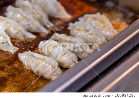 Bake gyoza with a commercial gyoza machine 106954283