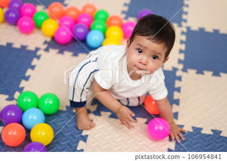 infant baby playing colorful balls in playpen infant baby playing colorful balls in playpen 106954841