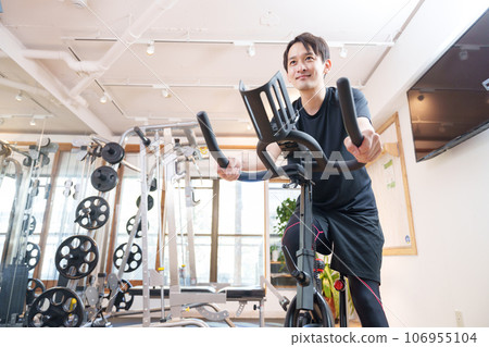 一名男子在健身房騎健身車鍛煉（健康/飲食） 106955104