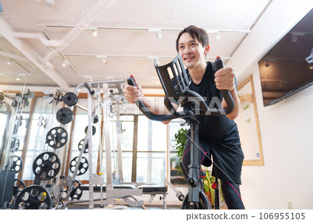 一名男子在健身房騎健身車鍛煉（健康/飲食） 106955105