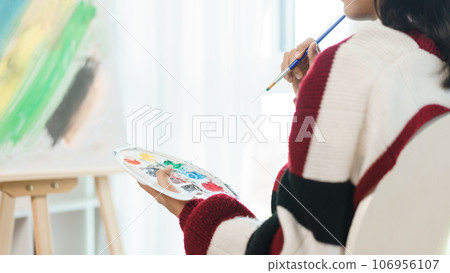 The art concept, Asian female artist sitting front of canvas and thinking to create about artwork 106956107