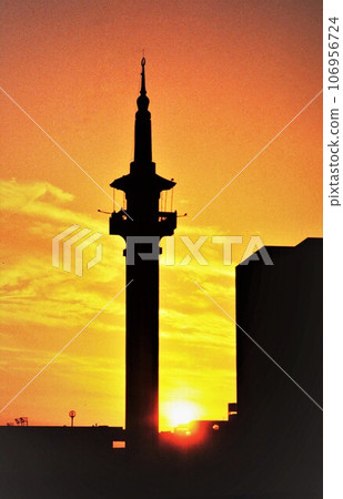 Mina red call tower of the mosque (chapel) reflected in the setting sun) Mina red call tower of the mosque (chapel) reflected in the setting sun) 106956724