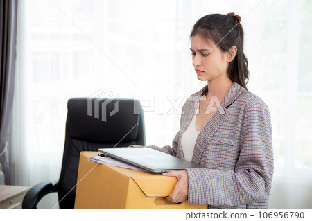 Portrait young woman employee carrying cardboard box or belonging with frustrated and stress. 106956790