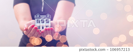 The concept of buying and selling real estate. A man with a model of a house on the background of the forex chart. 106957213