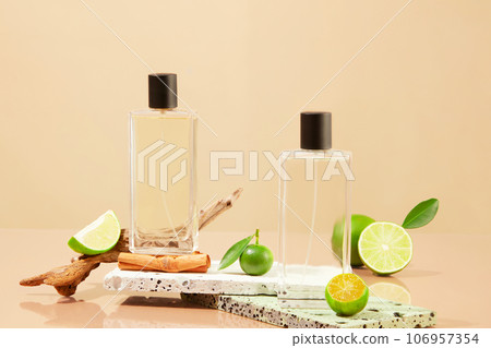 Front view of two blank label spray bottles decorated with kumquat and limes slices. Essential oils extracted from lemon and kumquat have a very gentle fragrance Front view of two blank label spray bottles decorated with kumquat and limes slices. Essential oils extracted from lemon and kumquat have a very gentle fragrance 106957354