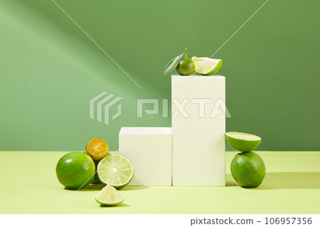 Podiums in square and rectangle shaped are arranged with halves of kumquat and lime. Blank space on the podium for products or goods presentation 106957356