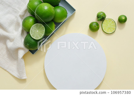 Empty podium in white color displayed with a tray of white towel with kumquat and lime. Vacant space to display natural beauty product extracted from Lime and Kumquat 106957380