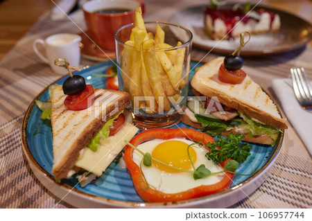 Scrambled egg sandwich with cream cheese on rye toast for breakfast on white background. Healthy breakfast or snack. Scrambled egg sandwich with cream cheese on rye toast for breakfast on white background. Healthy breakfast or snack. 106957744
